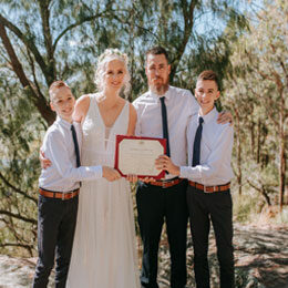 Family holding up a marriage certificate just after their Elopement in the Blue Mountains
